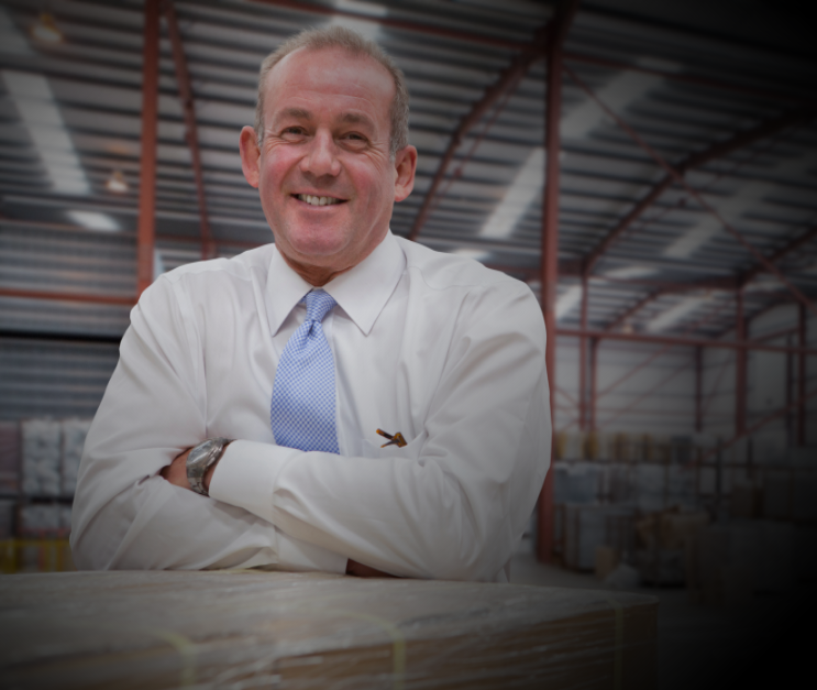 man leaning against boxes of widgets on factory floor